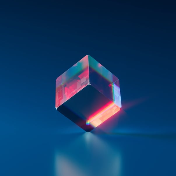 transparent cube balancing on corner with red light refracting from it